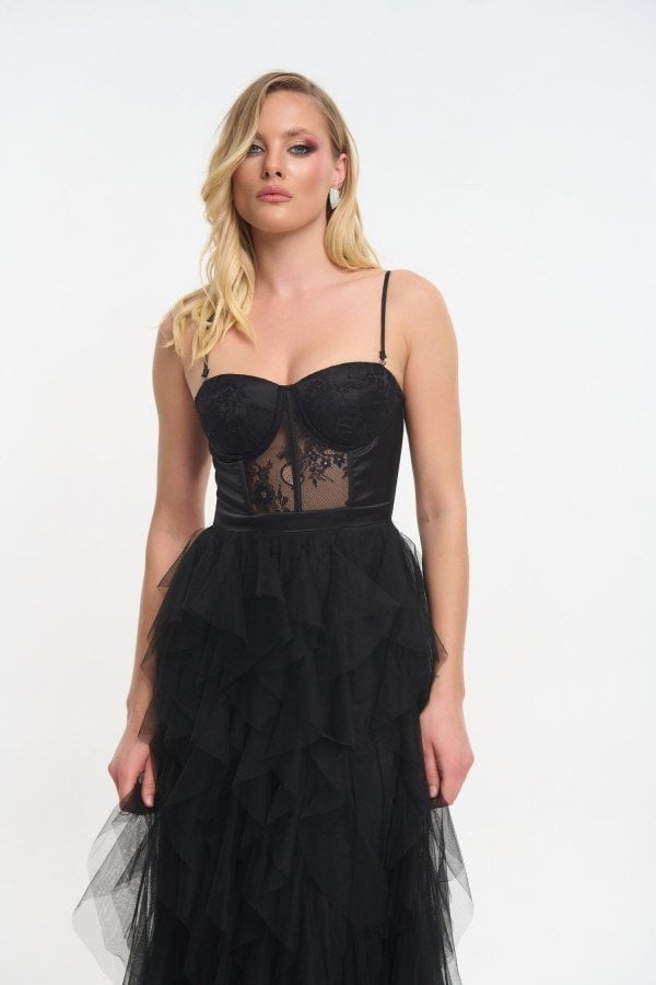 Λεπτομέρεια strapless μπούστου με δαντέλα μαύρου φορέματος και αρχή βολάν φούστας.