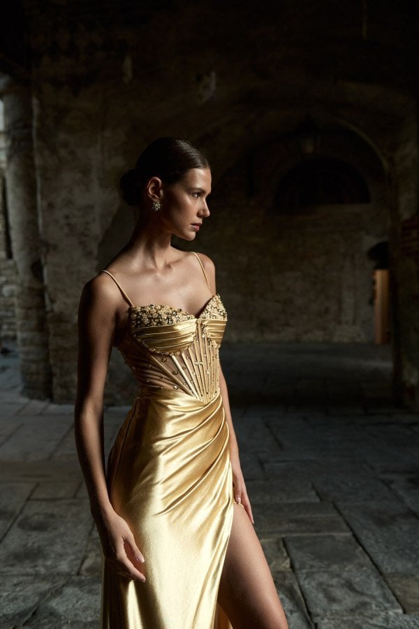 Το light gold φόρεμα σε τριών τετάρτων όψη, με λεπτές τιράντες και κεντητό κορσέ