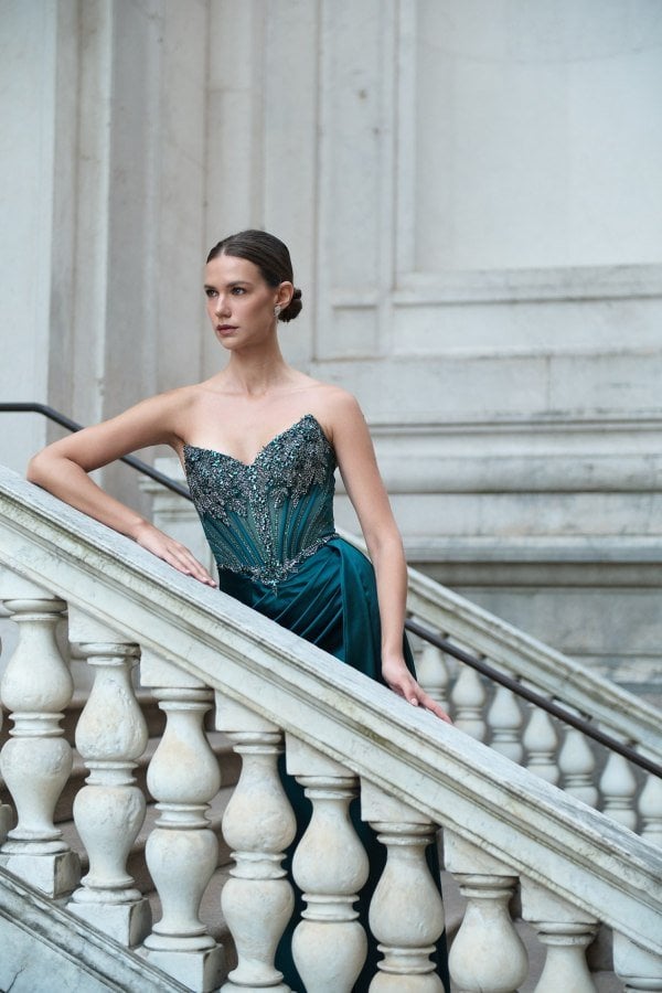 Το strapless μπούστο και οι μπανέλες του πετρόλ σατέν φορέματος, πλάγια λήψη